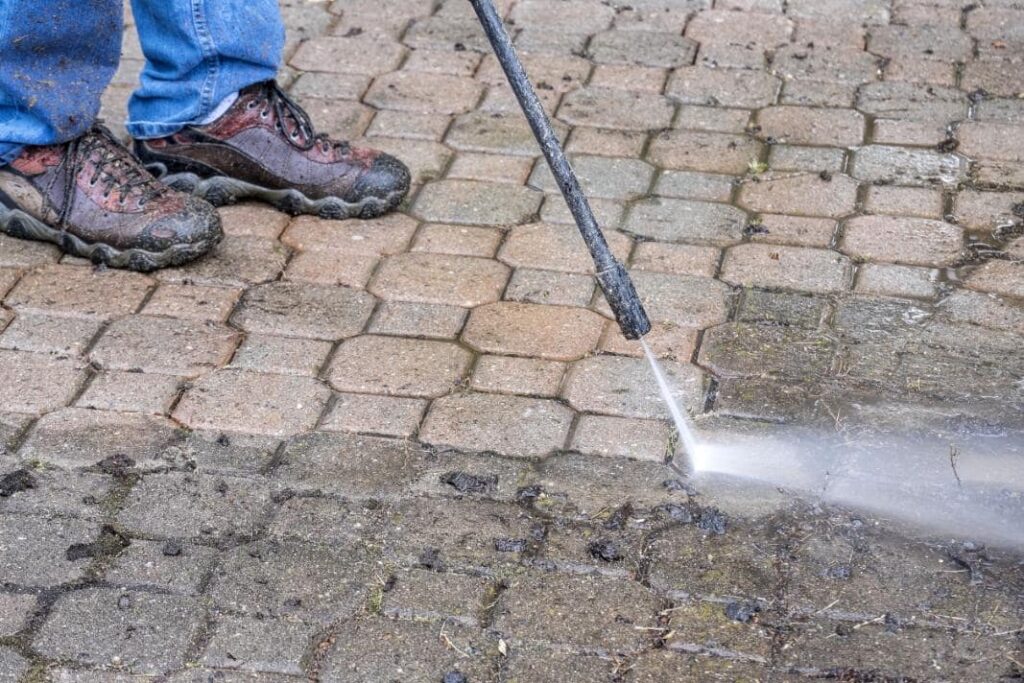 30507824 man cleaning patio with a power washer